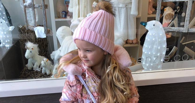 A girl modelling a pink wholly hat at Betty McKenzie